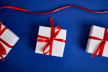 Fototapeta na wymiar Luxury white gift boxes with red ribbon