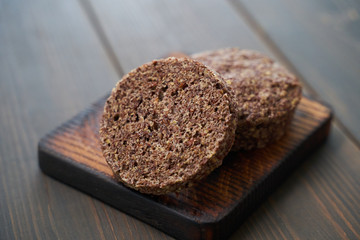Keto bread. Tasty almond flour ketogenic buns, homemade with crust and sesame seeds on wooden board.