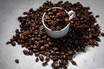 A cup of espresso with coffee beans on a white background