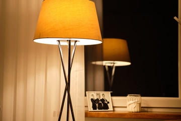 Lampa oświetlająca ciepłym światłem fotografię na parapecie okna