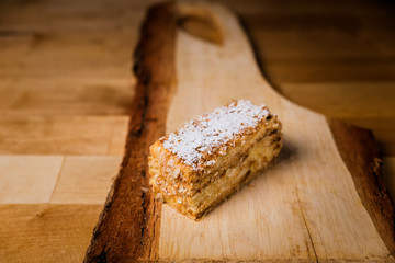 Fototapeta na wymiar A piece of napoleon cake on wooden board