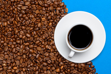 coffee beans and cup with coffee on a blue background