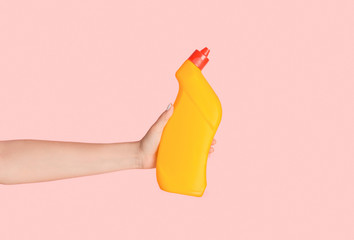 Unrecognizable girl showing toilet desinfectant gel on pink background, closeup. Space for design