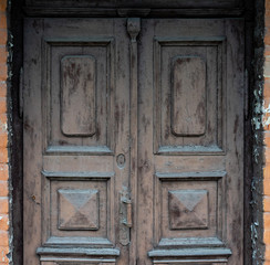 Old wooden doors are painted brown with colorless paint
