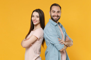 Smiling young couple two friends guy girl in pastel blue casual clothes isolated on yellow wall...