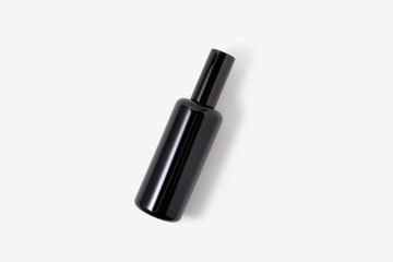 Black glass cosmetic or parfum spray bottle on white background. Face, body skin or hair care. Health and beauty