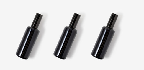 Three black glass cosmetic or parfum spray bottles on white background. Face, body skin or hair care. Health and beauty. Spa and cosmetology. Detox.