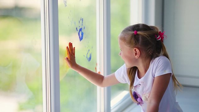 Children girl draw with palms on the window. Painted hands leave a mark on the glass. Quarantine. Stay home. Flash mob society community on self-isolation quarantine pandemic coronavirus.