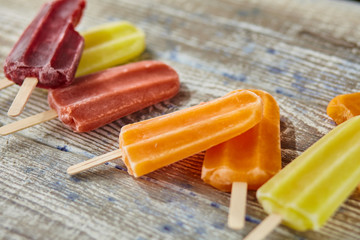 Ice cream on a stick on the wooden table