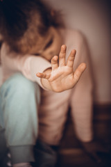 Stop violence and abused children. Sad little girl sitting in room. Human rights or refugee day concept.