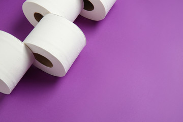 Rolls of toilet paper on color background