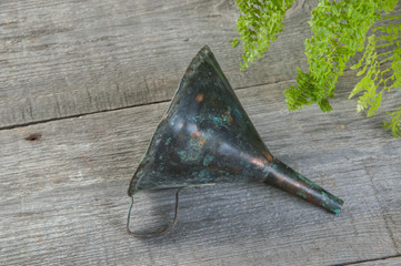 Antique brass funnel with handle on wooden background