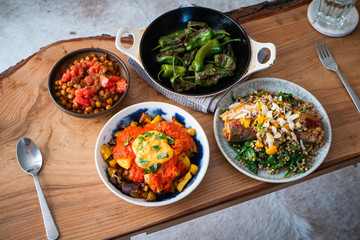 Patatas Bravas in a bowl, surrounded by healthy foods.
