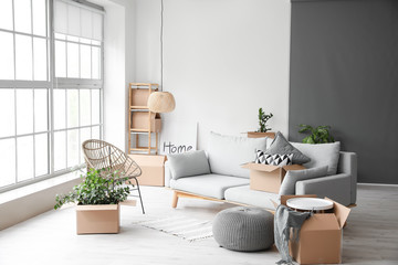 Cardboard boxes with belongings in new flat on moving day