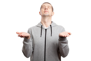 believing male athlete prays for The Islamic, his palms directed towards the sky, his eyes closed, his head raised upwards. Dressed in sportswear, short haircut. Isolated