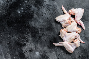 Raw chicken wings, organic poultry meat. Black background. Top view. Copy space