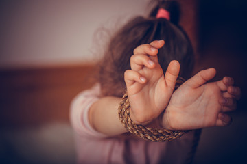 Rope on girls hand on dramatic background. International human rights or refugee day concept. The topic of freedom of speech.