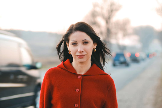 Woman In Red Coat On Road