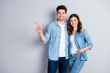 Portrait of positive cheerful couple spouse point index finger present advert promotion wear casual...