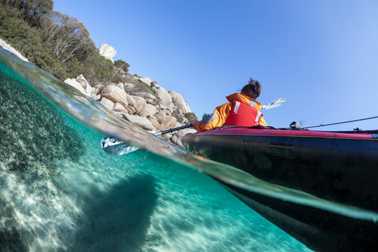 Femme en kayak sur la mer près des côtes.