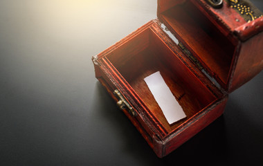 empty piece of paper in antique wooden chest, blank treasure box on the black table