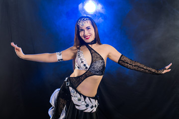 Portrait of a woman in oriental costume performing belly dance. Tribal fusion dance concept.