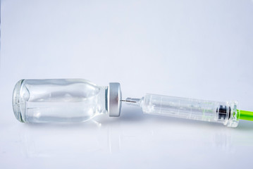 Syringe and a glass bottle with vaccine white background