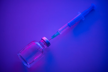 medical ampoule and syringe on blue background.