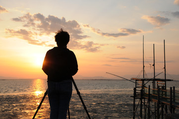 有明海に沈む夕日を撮影するカメラマン