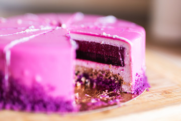 Pink and violet birthday cake without one piece. Dessert, holidays and delicious concept.