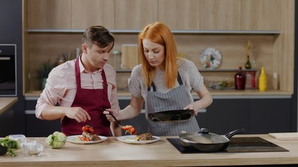 Cooking show hosts chefs, male and female, cooking meat. Morning TV cooking programme