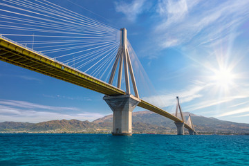 Modern Bridge against blue sky with sun. Rion-Antirion Bridge