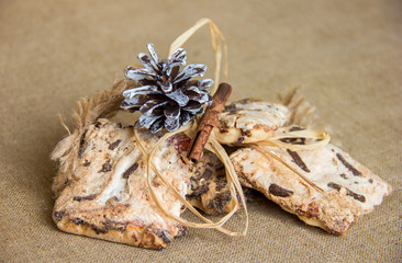 Cookies with candied vanilla stick and pine cone on canvas, Christmas traditions natural sweets,...