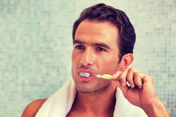 Young attractive man brushing his teeth in the bathroom
