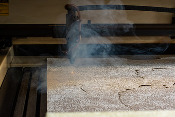 laser machine burns out stencils form on paper for the production of metal products