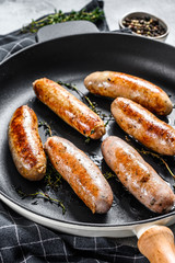Tasty homemade sausages in a pan. Pork, beef and chicken meat.  Gray background. Top view