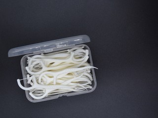 Dental floss with handles on a black background.