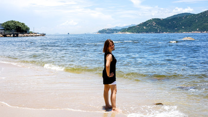 Young happy beautiful girl on a vacation at the sea, island life, sunny hot weather in Hong Kong, beach walk, travel relax concept