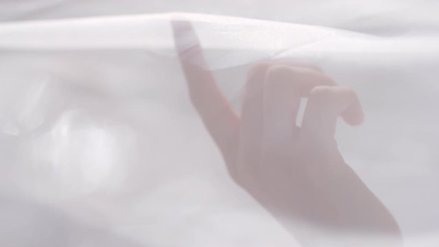  Slowmo close up of young woman lying in bed and touching sheer canopy
