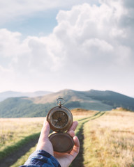 Man with compass in hand on mountains road. Travel concept. Landscape photography © Ivan Kmit