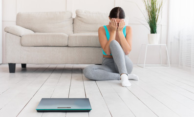 Girl Crying Sitting Near Scales Gaining Excess Weight At Home