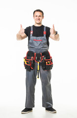 Portrait of happy handyman with tools showing thumbs up sign on white background