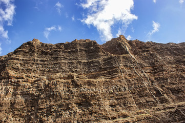 Cliff of colored rocks. Los Gigantes rocks - a close-up view from below.