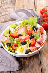 mixed vegetable salad with egg, ham, olive and tomato