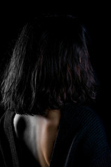Close-up detail photo of young woman wearing open back blouse on black background. Colorful, black and white. Creative concept.