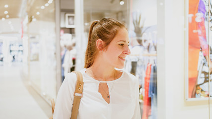 Portrait of young beautiful woman walking in shopping mall during season sale