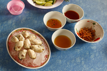 Fresh mussels lie in a plate with ice on the table. Selection of a variety of mussels sauces. Asian delicacies and seafood.