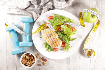 grilled chicken fillet with salad and meter tape- diet food concept