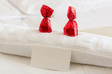 Candy and empty business card on a hotel bed