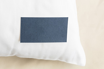 Blank paper business card on a hotel pillow